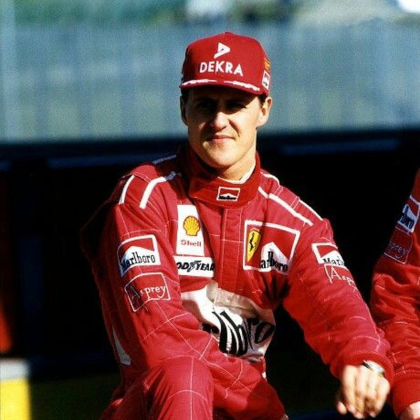 Close-up of Schumacher’s 1997 F1 race suit, displaying detailed stitching and rich red fabric, with sponsor logos highlighting his drive during the 1997 season.